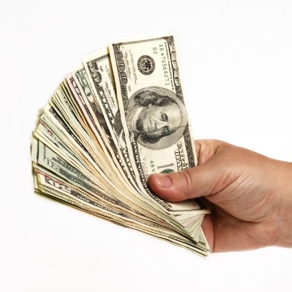 hand holding stack of hundred dollar bills