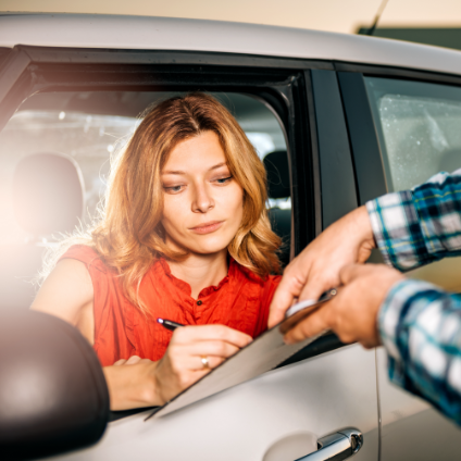woman in car filling out checklist